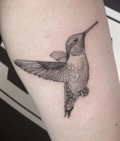 a small black and white tattoo of a hummingbird