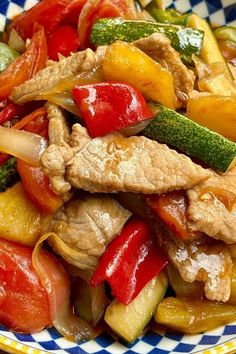 a plate filled with meat and vegetables on top of a checkered table cloth