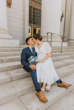 a man and woman sitting on steps kissing