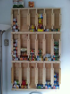 the shelves are made out of wood and have different types of food in them on them