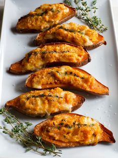 baked sweet potatoes with cheese and herbs on a white plate