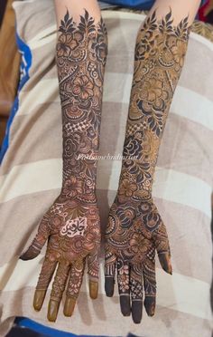 two hands with henna tattoos on them