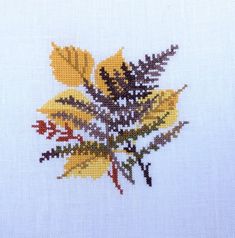 the cross stitch pattern shows yellow and brown leaves