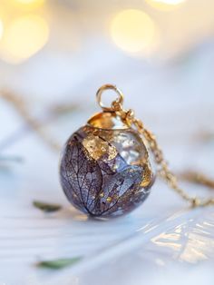 a necklace with a glass ball hanging from it's chain