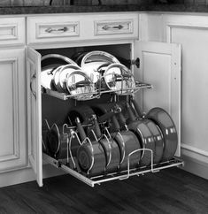 an open dish rack with many pots and pans on it in a white kitchen