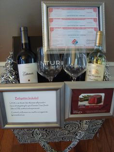 three wine glasses sitting on top of a table next to bottles of wine and an award plaque