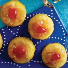 pineapple upside down cookies with jelly on blue serving tray next to silverware and polka dot napkin