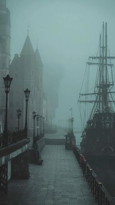 a boat is docked in the harbor on a foggy day