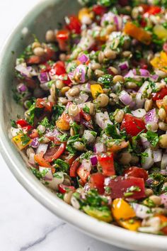 a white bowl filled with lots of food on top of a table