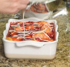 someone is pouring sauce into a casserole dish