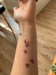 a person with a wrist tattoo that has three stars and two moon on the arm