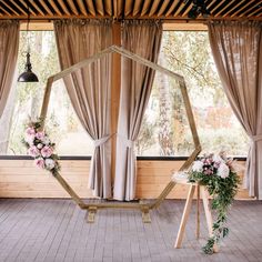 an indoor ceremony setup with flowers and greenery in the center, hanging from wooden beams