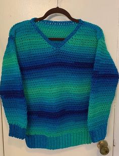 Pullover V neck ombre sweater crocheted in varied blues and green! Small to Medium. Washable (gentle cycle, low heat dry) Measurements: Chest: 34 in Length: 26 in Free Shipping! For more unique handmade sweaters, click here: https://www.etsy.com/shop/ChristianneCrochets?ref=seller-platform-mcnav&section_id=31124024 See all the handmade items available in my shop: https://www.etsy.com/shop/ChristianneCrochets Blue Knit Long Sleeve V-neck Sweater, Blue Cotton V-neck Sweater For Winter, Blue Knit V-neck Sweater For Winter, Blue Cotton Crochet Sweater, Green Crochet Winter Top, Green Crochet Top For Winter, Winter Blue Crochet Tops, Green Crochet Sweater Casual Style, Green Crochet Casual Sweater