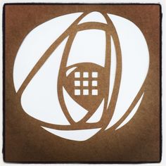 a brown and white paper cut out of a cell phone with the letter o on it