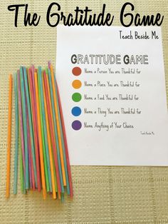 a group of colored straws sitting next to a paper with the words, the gratitude game