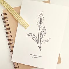 a notepad with a drawing of a flower on it next to a spiral notebook