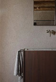 a bathroom sink sitting under a mirror next to a wooden cabinet