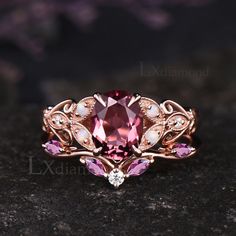 a close up view of a ring with pink and white stones