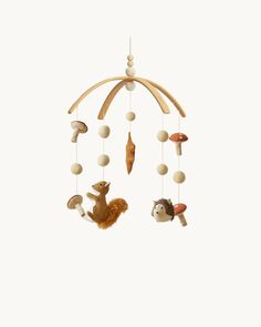 a wooden mobile with animals and mushrooms hanging from it's sides