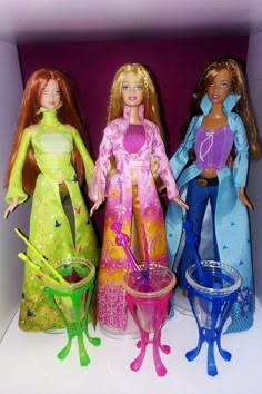 three barbie dolls standing next to each other