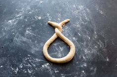 a piece of bread shaped like an oar on a black surface with white icing