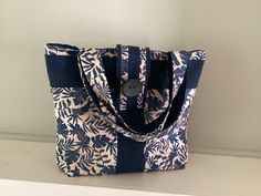 a blue and white tote bag sitting on top of a counter next to a wall