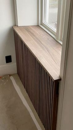 an empty room with a radiator next to a window