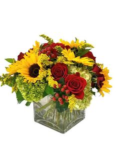 sunflowers, roses and other flowers in a square vase on a white background