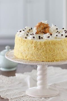 a cake with white frosting and chocolate sprinkles on top sitting on a plate