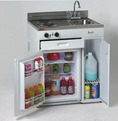 an open refrigerator with its door wide open and food in the bottom drawer is shown