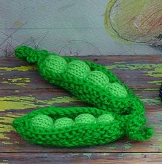 two crocheted peales sitting on top of a wooden table next to each other