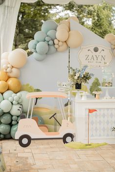 a golf cart is parked in front of balloons