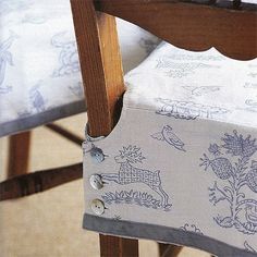 an upholstered chair with a blue and white fabric on it's back