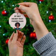 a woman holding up a christmas ornament that says, my only holiday treat passing exam