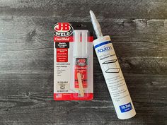 a pen and glue sitting next to each other on a wooden table with a package of glue