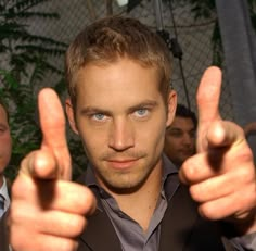 a man giving the thumbs up sign with two other men behind him