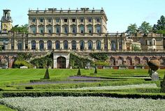 a large building with lots of hedges in front of it