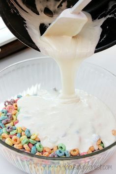 a bowl filled with cereal and milk being poured into it