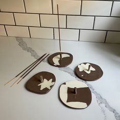 three brown and white plates sitting on top of a counter next to chopsticks