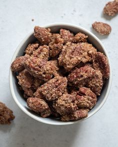 a white bowl filled with nuts on top of a table