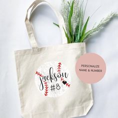 a personalized tote bag with the name and number on it next to a plant