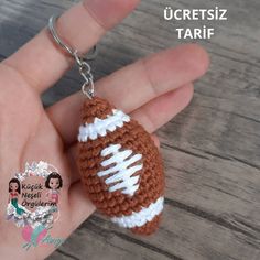 a crocheted football keychain is shown in the palm of someone's hand