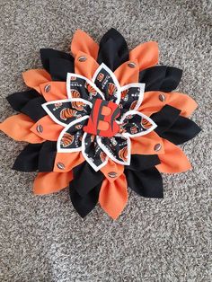 an orange and black flower on the ground with some sort of decoration attached to it