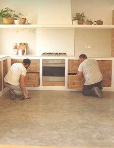 two men are working on the kitchen cabinets