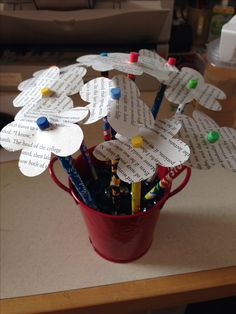 a red bucket filled with lots of paper flowers