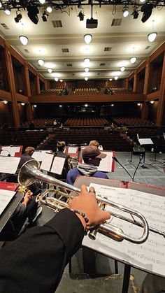 a person playing a trumpet in front of an orchestra