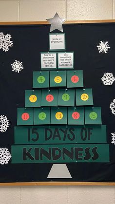 a bulletin board with a christmas tree made out of numbered boxes and snowflakes