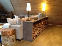 a living room filled with furniture next to a firewood log wall and a fireplace