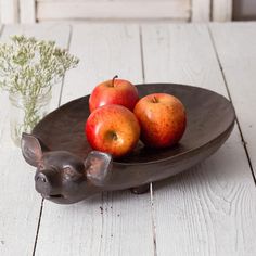 some apples and two small elephants on a plate