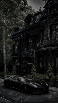 a black sports car parked in front of a large building on a city street at night